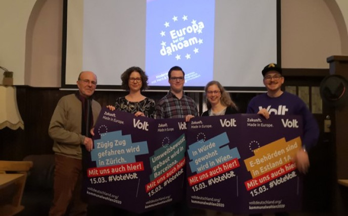 Volt-Mitglieder posieren mit Plakaten in der Hand