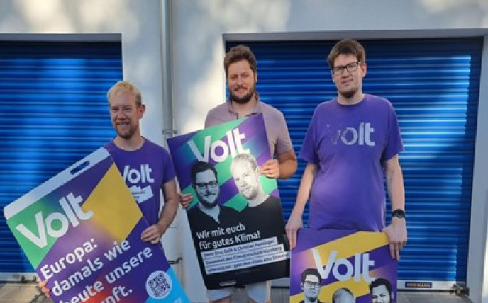 Volt-Mitglieder posieren mit den Plakaten die gleich verteilt und aufgehängt werden
