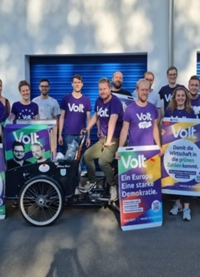 Gruppe Volt Mitglieder die mit Plakaten posieren