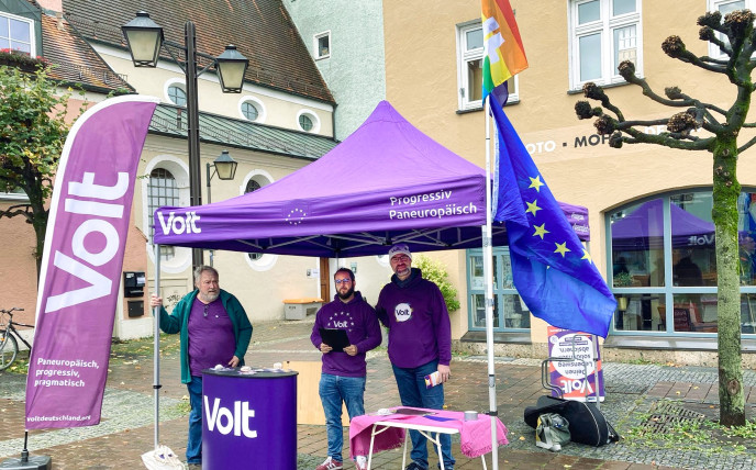 Drei Volt-Mitglieder am Volt Stand beim Wahlkampf.