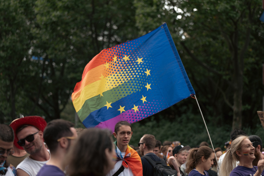 Volt Berlin nimmt an der Marzahn Pride 2025 teil. Foto: Eine Demonstration, auf der eine Teilnehmerin eine Euro-Pride-Flagge schwenkt.