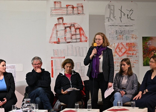 Foto: Valeska Huland (stehend) gibt ein Statement gegen die AfD ab. Auf dem Podium außerdem v.l.n.r. (sitzend): Jessica Rosenthal MdB (SPD), Jürgen Repschläger (Linke), Dr. Ursula Sautter (CDU), Anna Heimann (FDP), Katrin Uhlig MdB (Grüne). (Fotograf: Frank Fremerey, Volt Bonn).
