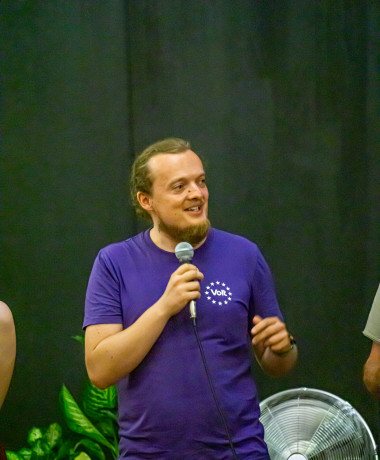 Johannes mit einem Volt T-Shirt und Mikrofon in der Hand