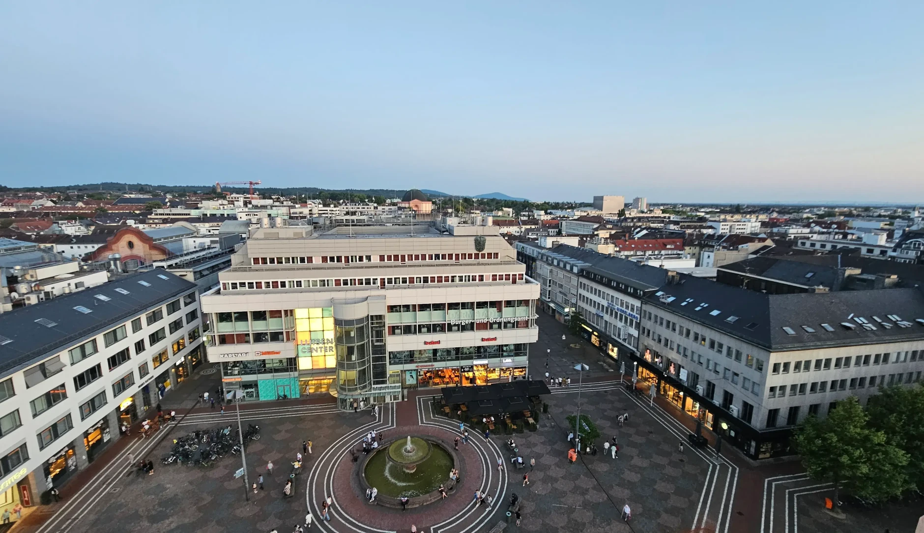 Blick auf den Luisenplatz von der Ludwigssäule Richtung Süden im Sommer 2025: Direkter Blick auf Brunnen, Luisencenter und umliegende Gebäude