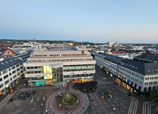 Blick auf den Luisenplatz von der Ludwigssäule Richtung Süden im Sommer 2025: Direkter Blick auf Brunnen, Luisencenter und umliegende Gebäude
