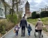 Bild einer Familie (Tocher, Vater, Sohn, Oma) beim Familienspaziergang, im Hintergrund der Hochzeitsturm auf der Mathildenhöhe Darmstadt (KI-generiertes Bild)