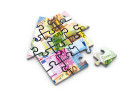 Ein hausförmiges Puzzzlespiel mit darauf abgebildeten Euro-Scheinen