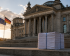 Bild des Bundestagsgebäudes in Berlin mit einem Packen Papier davor