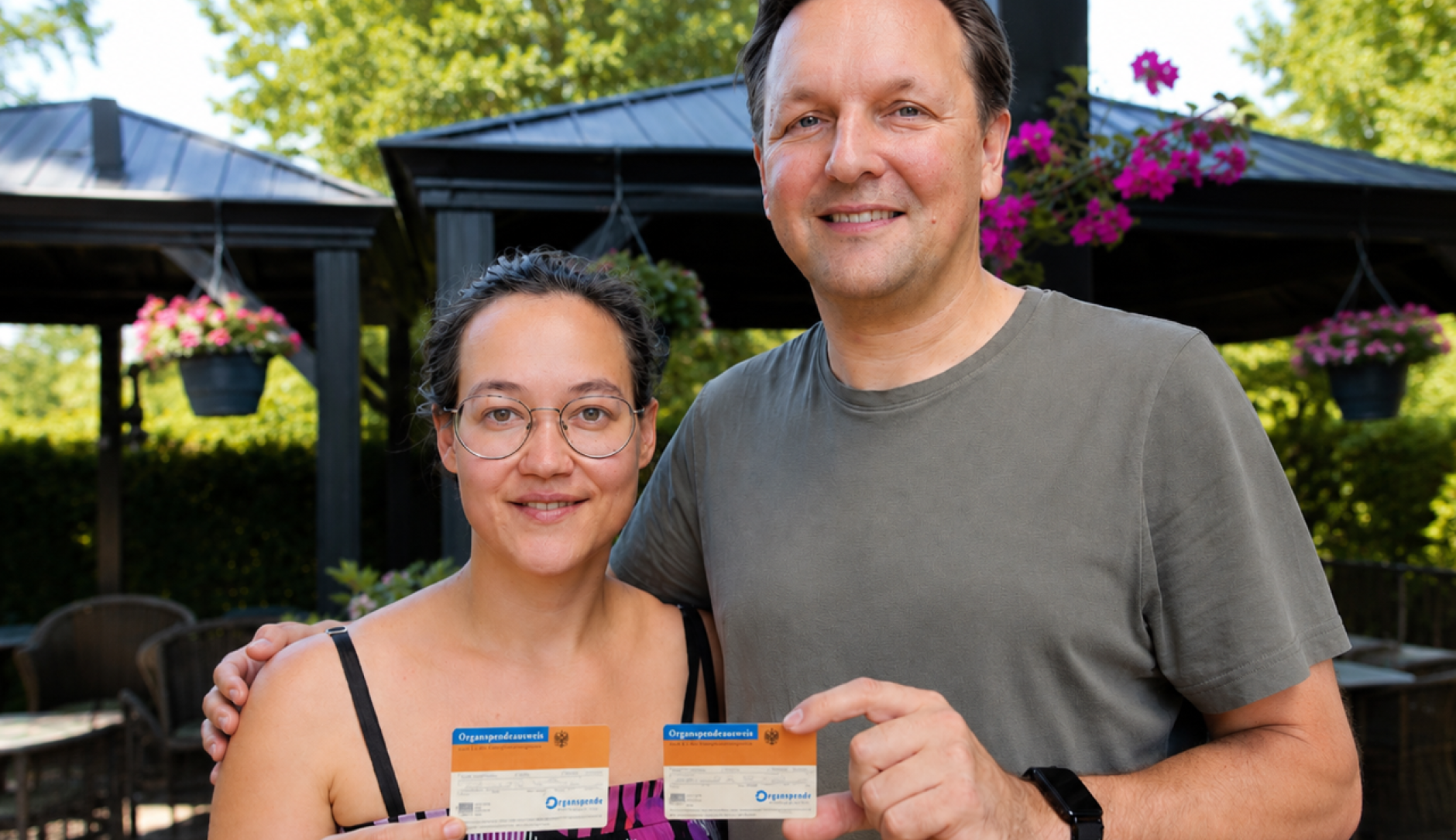 Alexandra Barsuhn und Tim Marton halten je einen Organspende-Ausweis hoch