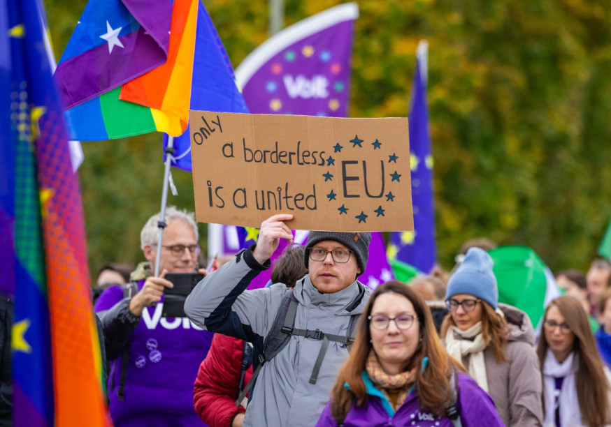 Foto einer Gruppe von Menschen mit Volt-Fahnen und einem Plakat