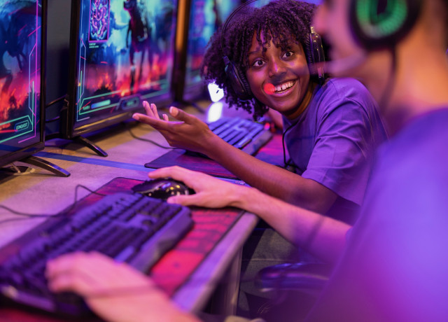 Person playing games in front of several computer screens