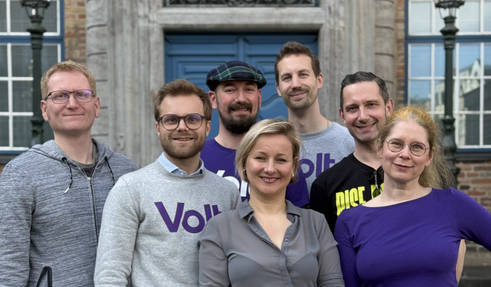 Die Kandidierenden von Volt Düsseldorf für die Kommunalwahl 2025 stehen vor dem Düsseldorfer Rathaus.