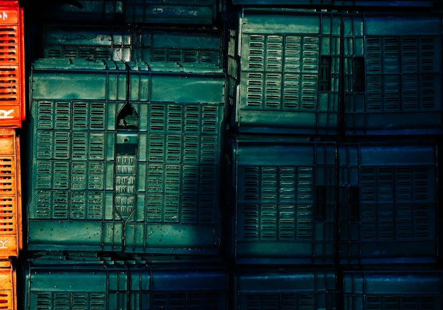 Das Bild zeigt verschiedene Aufbewahrungsboxen gestapelt. Links sind Boxen in Orange und rechts in einem Blaugrün. Foto zugeschnitten von Nandha Kumar auf Unsplash