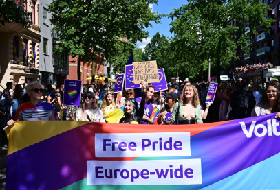 Ein großes Regenbogenbanner mit der Aufschrift: „Free Pride, Europe-wide“ führt die Demonstranten mit verschiedenen Demoschildern an. Viel violette Farbe und derSchriftzug Volt zeigt, dass es sich um eine Gruppe Volt Mitgliedern auf dem CSD handelt.