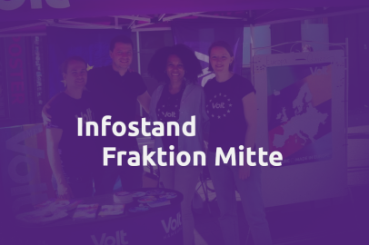 Im Hintergrund hinter Volt violetter Maske sehen wir vier freundliche Personen an einem Volt Stand. Im Vordergrund der Schriftzug: 