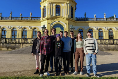 Hier stehen 9 Mitglieder des lokalen Kassler Teams vor der Orangerie in der Aue Kassels und werden von der Sonne angestrahlt