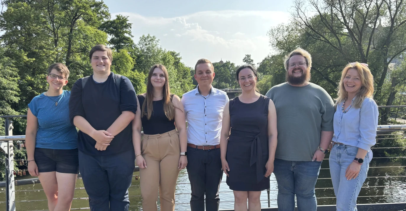Die Menschen des Landesvorstands Hessen stehen auf einer Brücke über einem Fluss.