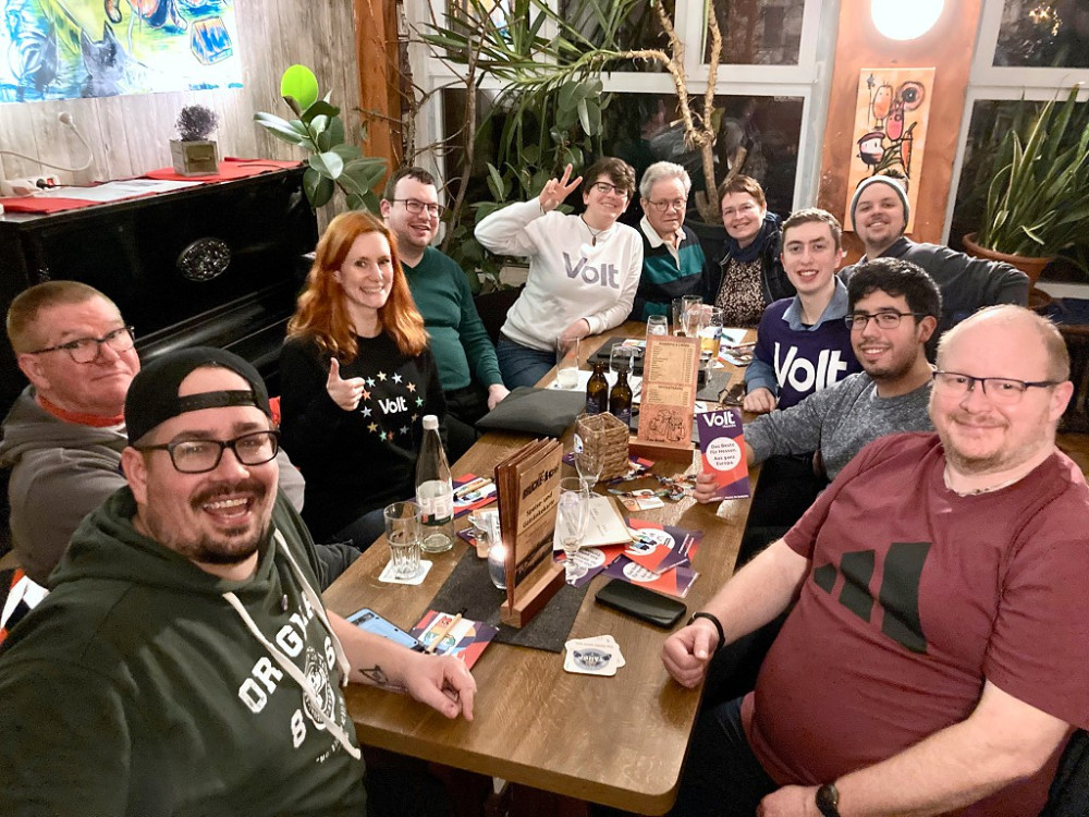 Team und Gäste von Volt Main-Kinzig-Wetter an einem Tisch im Brückenkopf Hanau