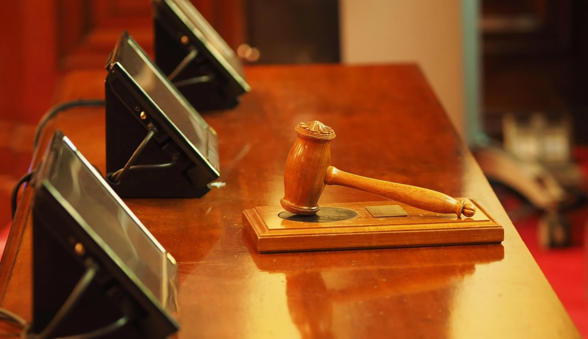 Symbolbild Tisch in einem Gericht mit Hammer