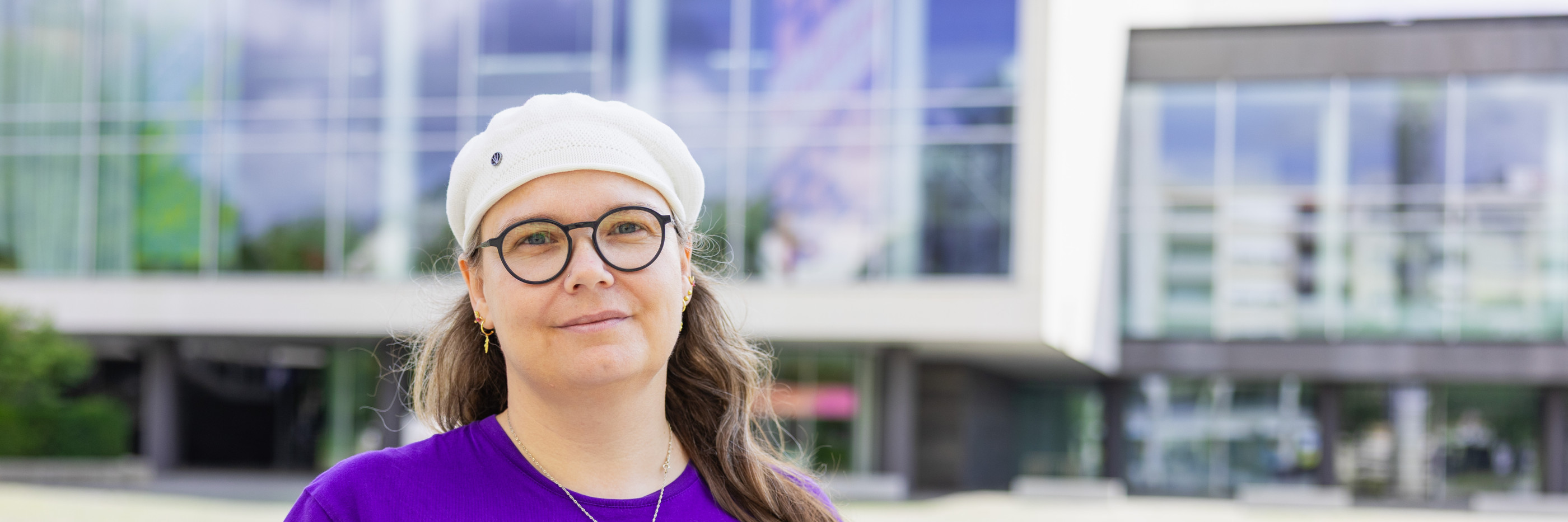 Auf dem Foto sieht man Michaela vor dem Pfalzbau mit direktem Blick in die Kamera. Sie lächelt freundlich. Foto: Thorsten Janz.