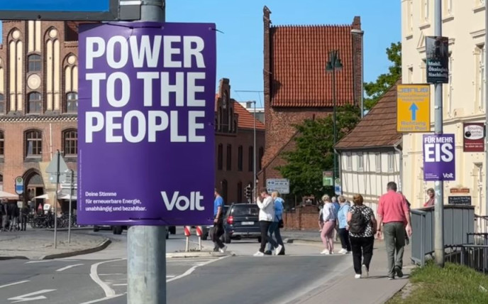 Lilanes Power to the People Plakat im Vordergrund einer Stadtszene