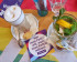 Latte macchiatto und Minztee auf einer regenbogenfarbigen Volt Flagge und Aufkleber von Volt