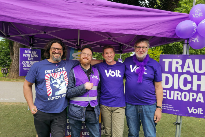 Wahlkampfstand mit vier lächelnden Volt Mitgliedern