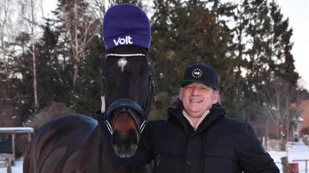 Local Lead Heiko Henning mit Pfred, welches eine Volt Mütze trägt.