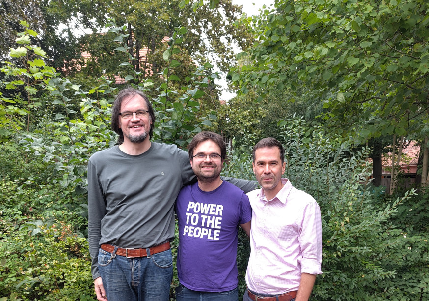 Tim Stüttgen, Martin Janßen und Julian Herrmann stehen gemeinsam vor einem Busch.