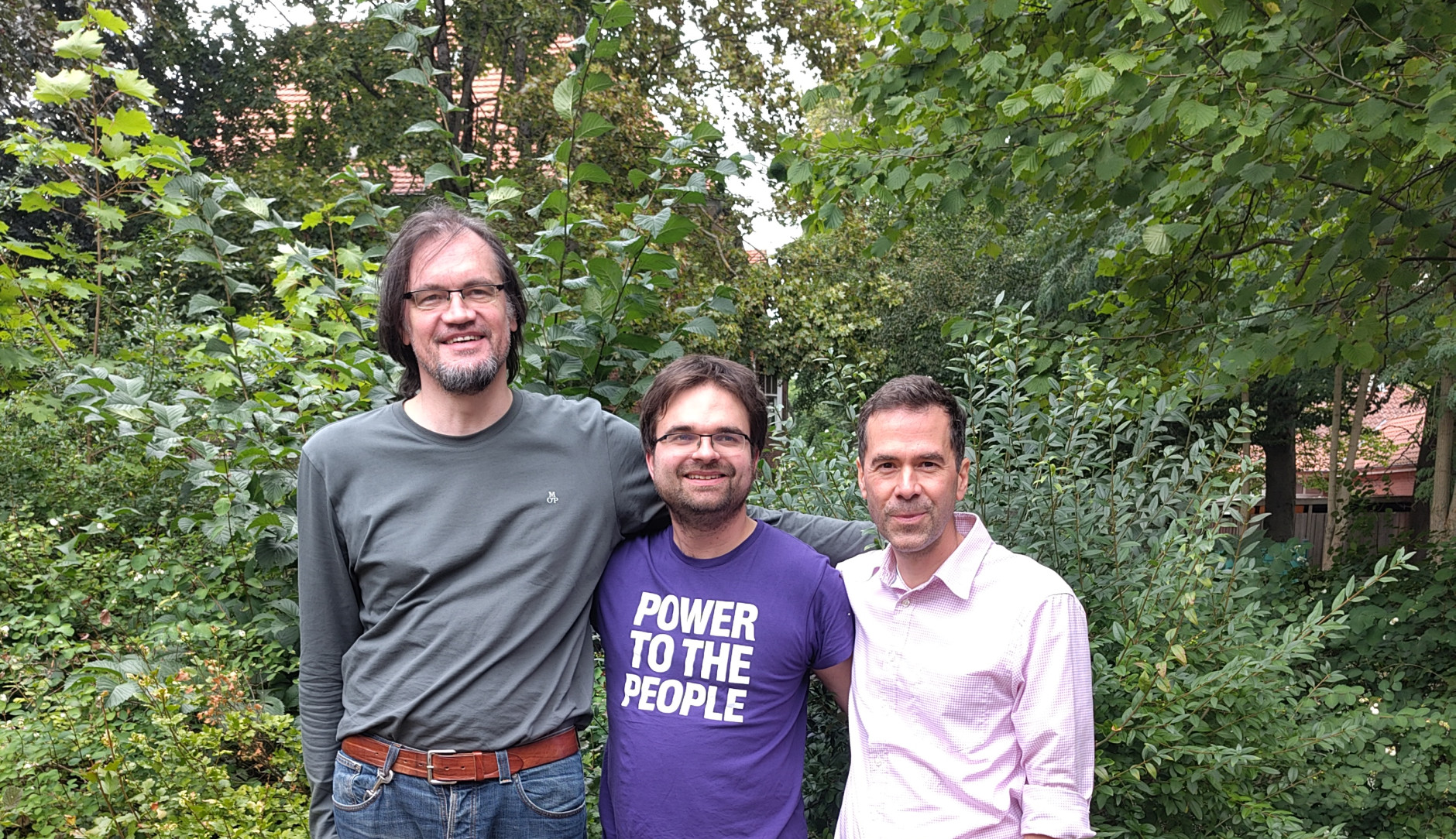 Tim Stüttgen, Martin Janßen und Julian Herrmann stehen gemeinsam vor einem Busch.
