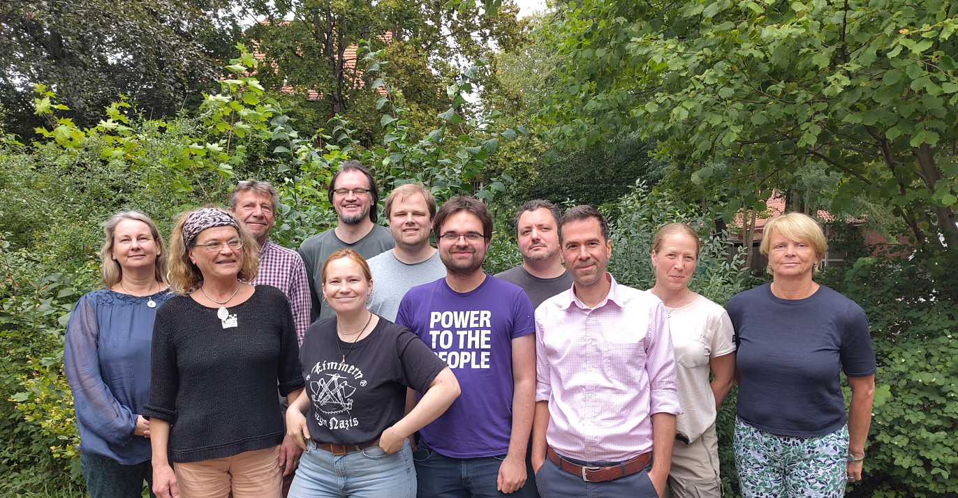 Das Lübecker Volt Team steht vor einem Busch.