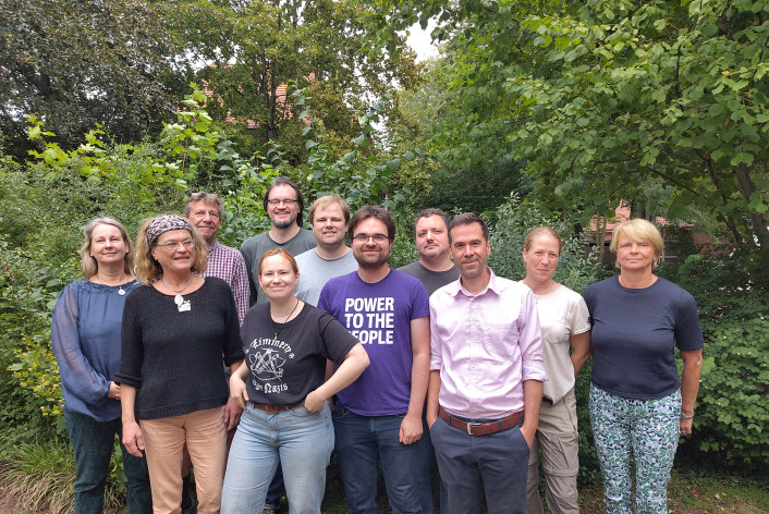 Das Lübecker Volt Team steht vor einem Busch.