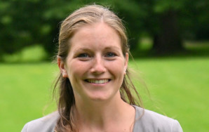 Kim Christin Holzmann steht lächelnd im Park.