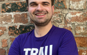 Martin Janßen steht im Volt T-Shirt vor einer Backsteinmauer.