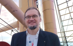 Tim Stüttgen sthet in einem Anzug for einem Mast.