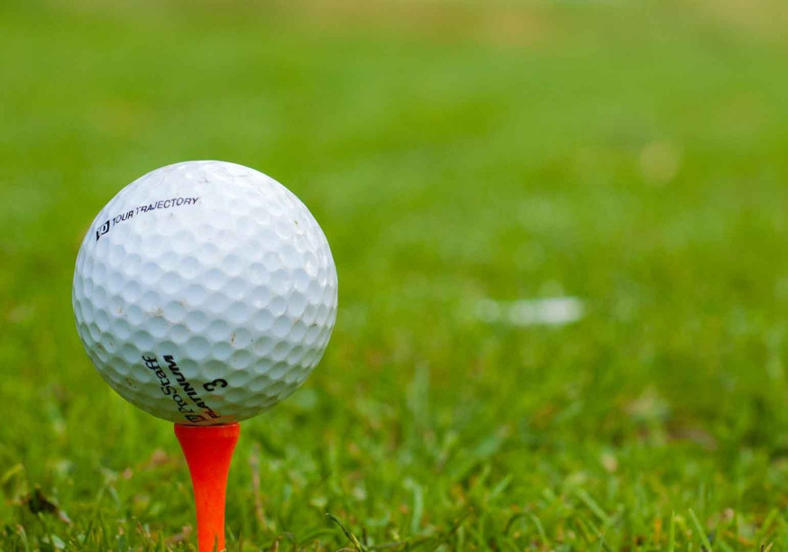 Ein Golfball liegt auf einem Tee.