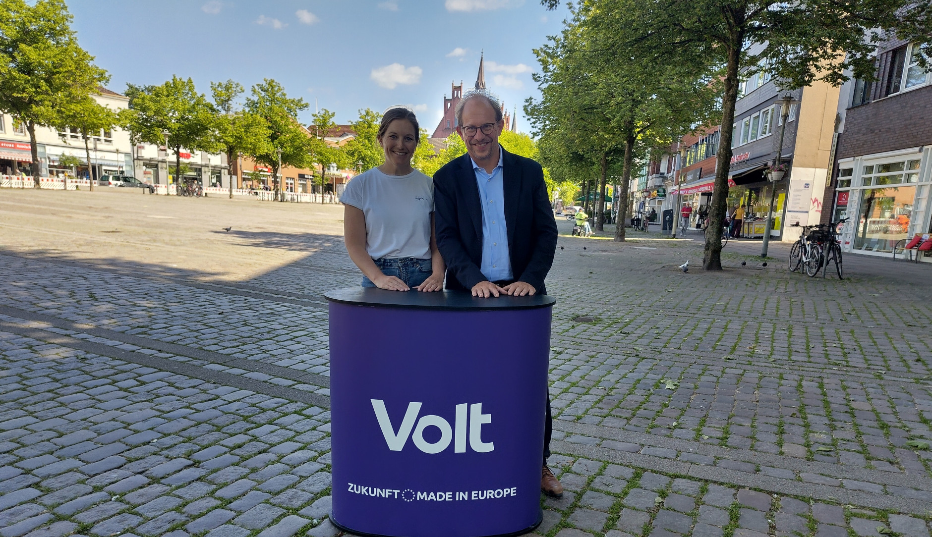 Tobias Bergman und Kim Christin Holzmann stehen vor dem Neumünsteraner Rathaus.