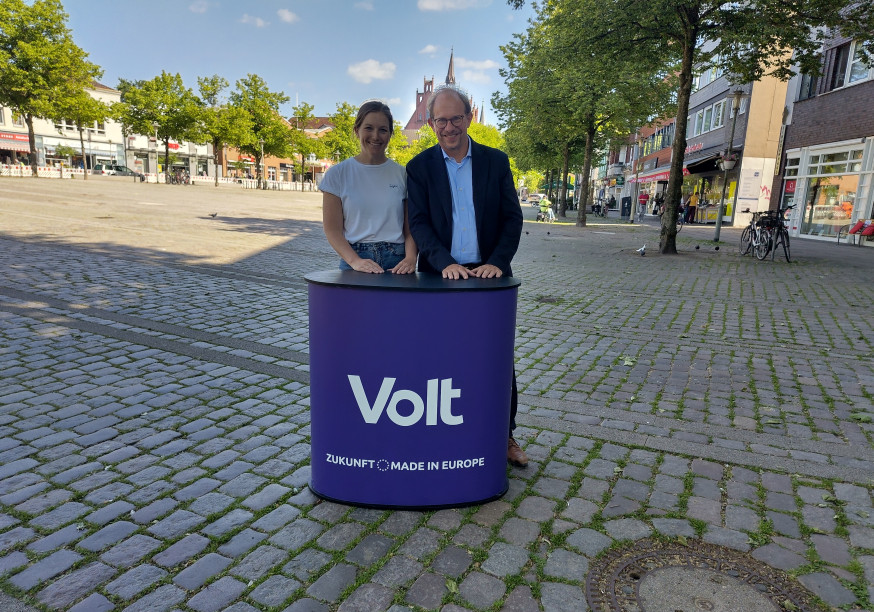 Tobias Bergman und Kim Christin Holzmann stehen vor dem Neumünsteraner Rathaus.