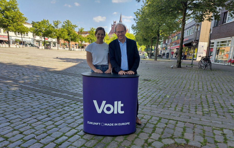 Tobias Bergman und Kim Christin Holzmann stehen vor dem Neumünsteraner Rathaus.