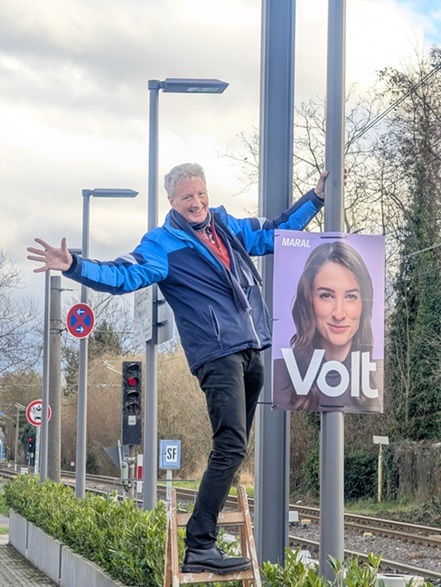Plakatieren macht Spaß! Ein Volt-Mitglied hängt in Bonn ein Wahlplakat zur Bundestagswahl auf (Foto: Frank Fremerey).